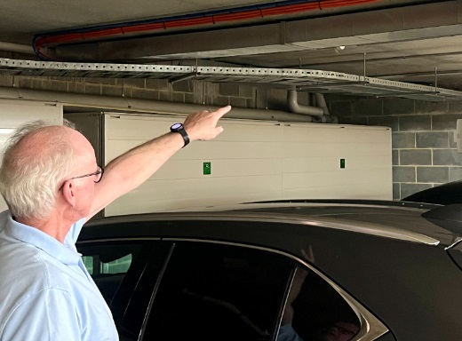 Man pointing to cable trays for wiring in car park